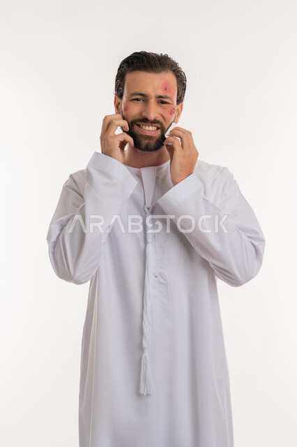 المشاكل الصحية والتهجيات، الإصابة بالحساسية الجلدية, بثور منتشرة على بشرة الوجه, بورتريه لرجل عربي خليجي اماراتي يرتدي الكندورة يقوم بالحك بإيماءات الإنزعاج والتعب, الشعور بالأوجاع والالام, خلفية بيضاء