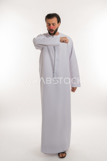 الاصابة بفايروس كورونا كوفيد19، الحاجة لتلقي العلاج، الانفلونزا والتهاب الرئة، بورتريه لرجل عربي خليجي اماراتي يرتدي الكندورة يرفع يده بايماءات السعال، الشعور بالمرض والكحة، صورة لكامل الجسم، خلفية بيضاء