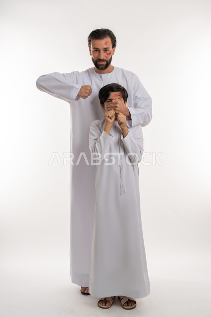 المشاكل والخلافات الاسرية، الغضب والسلوك العدواني, اصابات و جروح جسدية، قضايا اجتماعيه أسريه، بورتريه لولد عربي خليجي اماراتي يرتدي الكندورة يتعرض للعنف من قبل والده، ايماءات الآلم والحزن، صورة لكامل الجسم، خلفية بيضاء