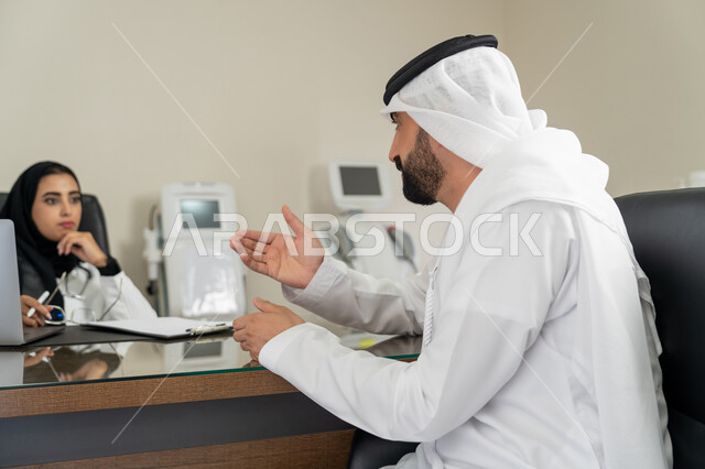 الاستشارات في المراكز الطبيه في الامارات العربية المتحدة, متابعة السجل الطبي للمراجعين, العمل في القطاعات الصحية, الاطلاع على نتائج التحاليل, بورتريه لطبيبة عربية خليجية اماراتية محجبة ترتدي المعطف الطبي تقوم بوصف الحالة المرضية للمريض, خلفية بيج