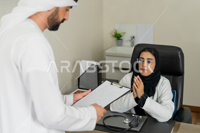 العمل في القطاعات الصحية, الاطلاع على نتائج التحاليل, تقديم الاستشارات في المراكز الطبيه في الامارات العربية المتحدة, متابعة السجل الطبي للمراجعين, بورتريه لطبيبة عربية خليجية اماراتية محجبة ترتدي المعطف الطبي تقوم بوصف الحالة المرضية للمريض, خلفية بيج