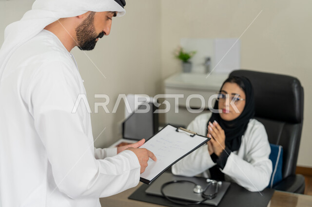 العمل في القطاعات الصحية, الاطلاع على نتائج التحاليل, تقديم الاستشارات في المراكز الطبيه في الامارات العربية المتحدة, متابعة السجل الطبي للمراجعين, بورتريه لطبيبة عربية خليجية اماراتية محجبة ترتدي المعطف الطبي تقوم بوصف الحالة المرضية للمريض, خلفية بيج