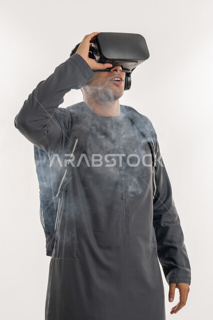 دمج الواقع الافتراضي بالتعليم والتدريب ، ارتداء نظارات العالم الخيالي، محاكاة للدخان والحرائق, بورتريه لطالب جامعي عربي خليجي إماراتي يرتدي الكندورة يحمل حقيبة على ظهره ويضع نظارة الفي ار ثلاثية الأبعاد، خلفية بيضاء