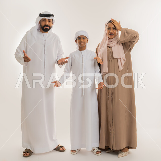 الشعور بالدهشة والصدمة والذهول، التفاجؤ من أمر معين، النظر الى الكاميرا بتعابير التعجب والاستغراب، التساؤل والاستفسارمن شيء ما، بورتريه لعائلة عربية خليجية اماراتية يرفعون أيديهم بإشارة الانبهار وعدم التصديق، صورة الجسم بالطول الكامل، خلفية بيضاء