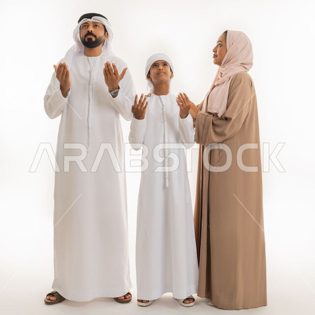 طلب المساعدة من المولى عز وجل، إيماءات التوسل والاسترحام، الحمد والشكر والتضرع  لله تعالى، بورتريه لعائلة عربية خليجية اماراتية ويقوموا برفع أيديهم للأعلى بهدف الدعاء بإيماءات السعادة والرضا، صورة الجسم بالطول الكامل، خلفية بيضاء