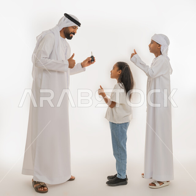ايماءات السعادة والسرور، إقتناء سيارة جديدة، بورتريه من الجانب لرجل عربي خليجي اماراتي يرتدي الكندورة والغترة يحمل بيده جهاز التحكم الالكتروني يقوم بمفاجأة ابنائه ويرفعون اصبع الابهام للأعلى بتعابير الاعجاب والرضا، صورة الجسم بالطول الكامل، خلفية بيضاء