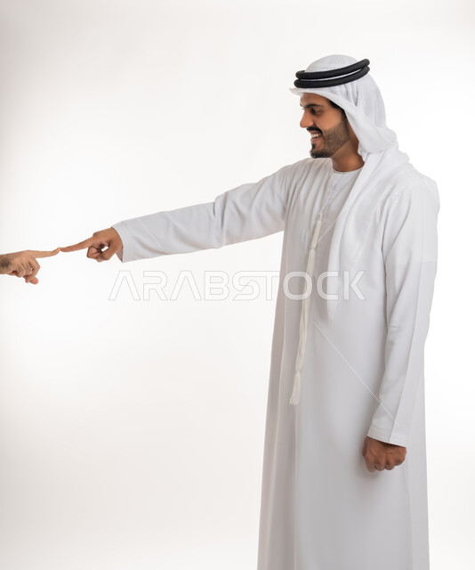 بناء علاقات و تكوين صداقات جديدة، الترحيب و السلام و إلقاء التحية، بورتريه لرجل عربي خليجي اماراتي يرتدي الكندورة والغترة البيضاء يقوم توجيه قبضة يده مقابل يد شخص آخر، ايماءات وحركات يدين تدل على التشجيع، صورة الجسم بالطول الكامل، خلفية بيضاء