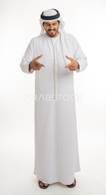 Using hands to measure something, determining volume and mass, portrait of an Arab Gulf Emirati man wearing a white kandura raising his hands in gestures of carrying an item, white background