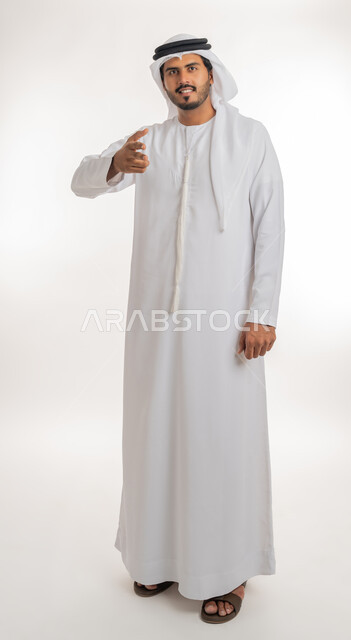 إلقاء التحيه والسلام, مفهوم الاستقبال والترحيب، بورتريه لرجل عربي خليجي إماراتي  يرتدي الكندورة والغترة البيضاء ينظر يمد يده بإيماءات المصافحة، التعارف و الصداقه وتكوين العلاقات, الجسم بالطول الكامل، خلفية بيضاء