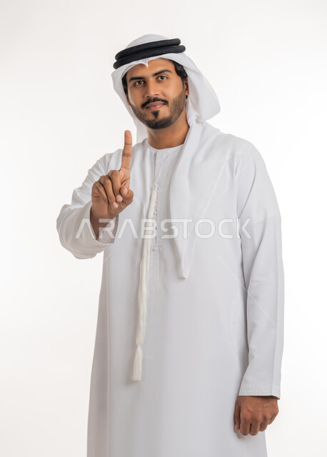 الدلالة على مكان عنصر،  الإشارة و التوضيح إلى شيء ما, تحديد موقع معين، بورتريه لرجل عربي خليجي إماراتي يرتدي الكندورة و الغترة البيض يشير بإصبع السبابة إلى شيء ما، خلفية بيضاء