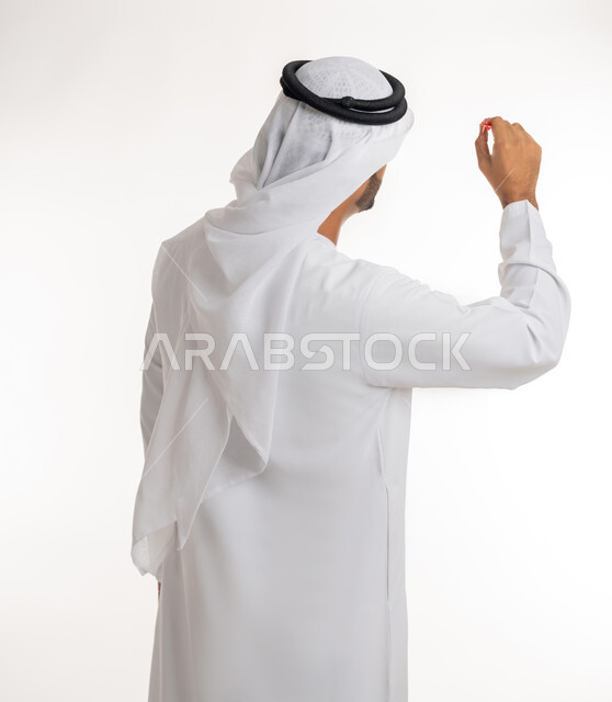مفهوم التصويب والتركيز، الدقة في تحديد الهدف، هوايات ومهارات رياضية، التسلية والترفيه والتحدي في رمي السهام، بورتريه لرجل عربي خليجي اماراتي يرتدي الكندورة البيضاء يمسك سهم مغناطيسي أحمر اللون، خلفية بيضاء