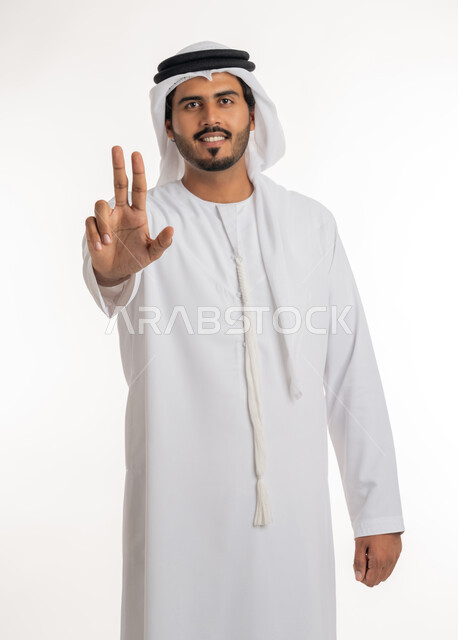 تعابير التحديد والتأكيد, الاشارة إلى شيء ما، اشارات تحدد هذا المكان (هنا)،  بورتريه لرجل عربي خليجي اماراتي يرتدي الكندورة والغترة البيضاء يقف باستقامة و يشير بثلاث أصابع للإختيار، خلفية بيضاء