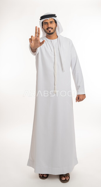 تعابير التحديد والتأكيد, الاشارة إلى شيء ما، اشارات تحدد هذا المكان (هنا)،  بورتريه لرجل عربي خليجي اماراتي يرتدي الكندورة والغترة البيضاء يقف باستقامة و يشير بثلاث أصابع للإختيار، خلفية بيضاء