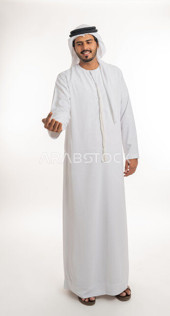 Pointing and explaining something, specifying a specific location, indicating the location of an item, portrait of an Arab Gulf Emirati man wearing a white kandura and ghutra pointing with his index finger to something, full body, white background