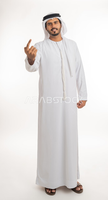 Pointing and explaining something, specifying a specific location, indicating the location of an item, portrait of an Arab Gulf Emirati man wearing a white kandura and ghutra pointing with his index finger to something, full body, white background