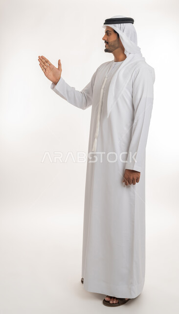 إلقاء التحيه والسلام, مفهوم الاستقبال والترحيب، بورتريه لرجل عربي خليجي إماراتي  يرتدي الكندورة والغترة البيضاء ينظر يمد يده بإيماءات المصافحة، التعارف و الصداقه وتكوين العلاقات, الجسم بالطول الكامل، خلفية بيضاء