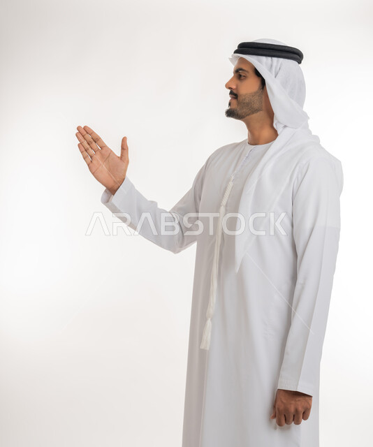 مفهوم الاستقبال والترحيب، إلقاء التحيه والسلام، بورتريه مقرب لرجل عربي خليجي إماراتي  يرتدي الكندورة والغترة البيضاء ينظر يمد يده بإيماءات المصافحة، التعارف و الصداقه وتكوين العلاقات، خلفية بيضاء
