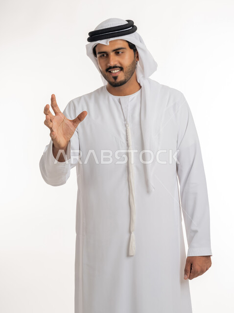 Containing and holding an item, the concept of elegance and attention to external appearance, a close-up portrait of an Emirati Gulf Arab man wearing a kandora and a ghutra, extending his hand forward, trying to capture three-dimensional holographic elements, white background.