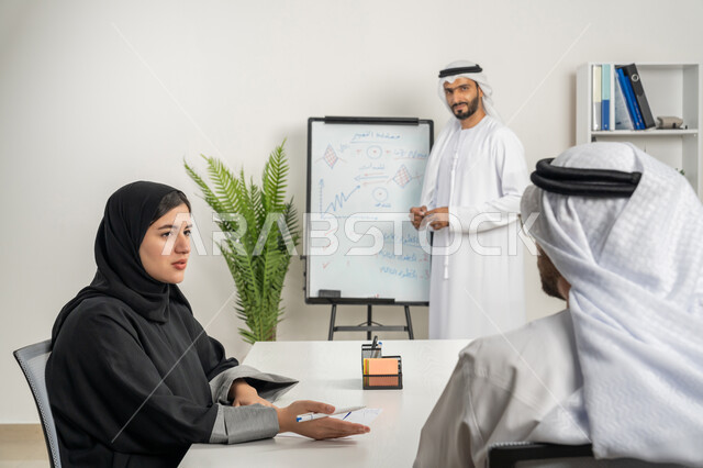 وضع الخطط الاستراتيجية لتحقيق الأهداف، استخدام السبورة لتوضيح الأفكار، مجموعة من الموظفين العرب الخليجيين الاماراتيين يعقدون اجتماع داخل مقر الشركة، تعلم اساليب العمل والتطوير المهني، مهن ووظائف ادارية مكتبية، العمل الجماعي وروح الفريق، مفهوم الإدارة المتعاونة