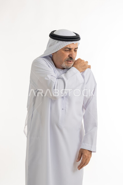 الحاجه لوضع خطة علاجية, طلب المساعده للذهاب الى المستشفى، الإحساس بالتعب والإرهاق, إيماءات الألم في الجسد، التهاب العضلات والمفاصل، بورتريه لرجل مسن عربي اماراتي خليجي يرتدي الكندورة و الغترة يضع يده على كتفه بتعابير الوجع، خلفية بيضاء