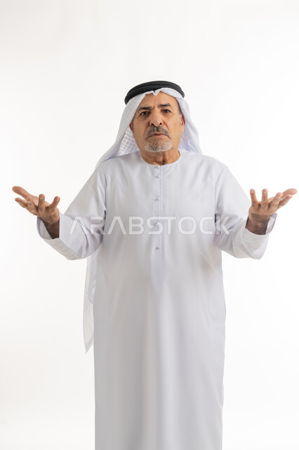 الإستغراب والاستفسار عن أمر ما، الإستفهام حول موضوع معين, بورتريه لرجل كبير بالسن عربي خليجي اماراتي يرتدي الكندورة والغترة يرفع يديه نحو الأعلى بإيماءات عدم المعرفة, الغموض وعدم الوضوح، صورة الجسم بالطول الكامل، خلفية بيضاء