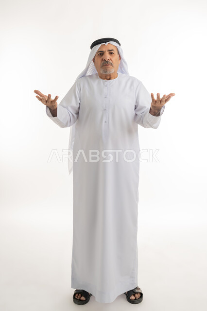 الإستفهام حول موضوع معين, بورتريه لرجل كبير بالسن عربي خليجي اماراتي يرتدي الكندورة والغترة يرفع يديه نحو الأعلى بإيماءات عدم المعرفة, الغموض وعدم الوضوح، الإستغراب والاستفسار عن أمر ما، خلفية بيضاء