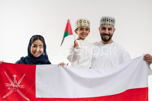 اعياد ومناسبات وطنية, الفخر بإنجازات الوطن وثقافته, الاحتفال باليوم الوطني العماني 18 نوفمبر, إحياء ذكرى تأسيس الدولة 1775 م, بورتريه لرجل عربي خليجي عماني يرتدي الكمة والدشداشة يقف مع زوجته و ابنه يحتفلان بتوحيد السلطنة، خلفية بيضاء