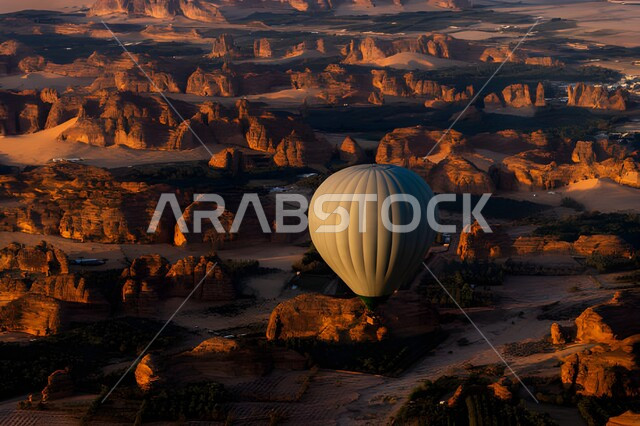 A flying balloon over rock formations and formations, natural sedimentary rocks, rock sculpture in desert areas, places of attraction that attract tourists from all over the world, famous tourist attractions in the Kingdom of Saudi Arabia