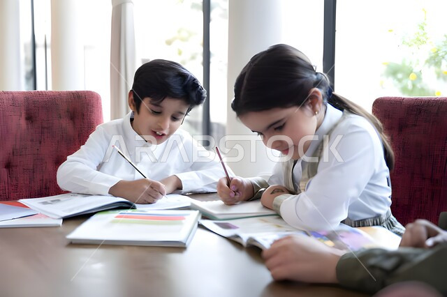 الاجتهاد والاستعداد للإختبارات المدرسية بإيماءات التركيز, صورة مقربة لطالب وطالبة يجلسان على الطاولة ويقوموا بحل الواجبات المنزلية, مفهوم التعلم و التثقف الذاتي, تنمية وتطوير مهارات الكتابة