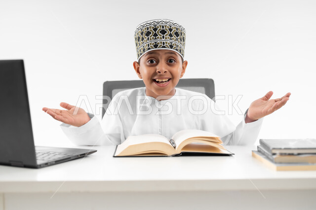 التساؤل والاستغراب والاستفسار من أمر ما، التردد وعدم الثقة بخصوص موضوع معين، استخدام الاجهزة التقنية الحديثة، بورتريه مقرب لصبي عربي خليجي عماني  يرتدي الدشداشة والكمة يرفع يديه بإيماءات عدم التأكد، مفهوم التعليم الإلكتروني، خلفية بيضاء