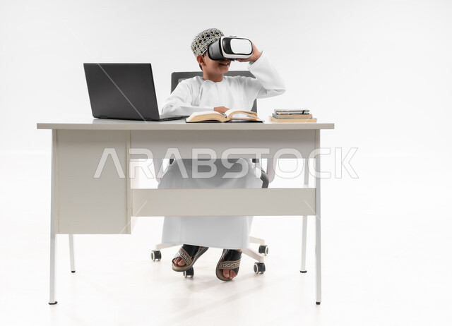 اتباع طرق تعليمية جديدة، مدارس وأكاديميات متطوره، التفاعل مع العالم الافتراضي، جمع التعلم مع الترفيه باستخدام التكنولوجيا الحديثة، بورتريه لصبي عربي خليجي عماني يرتدي الدشداشة والكمة يضع نظارة الفي ار، صورة لكامل الجسم، خلفية بيضاء