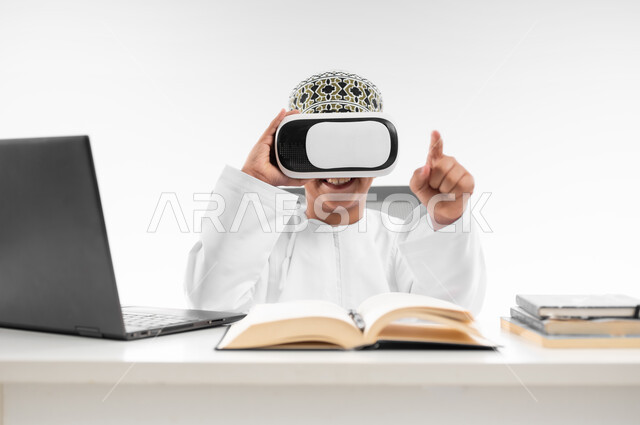 Interacting with the virtual world, combining learning with entertainment using modern technology, advanced schools and academies, following new educational methods, close-up portrait of an Arab Gulf Omani boy wearing a dishdasha and a thobe, wearing VR glasses pointing at something, white background