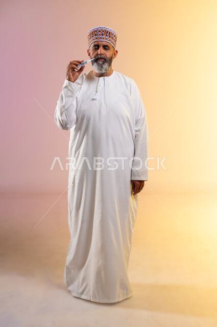 Necessity of visiting a doctor to develop a treatment plan, feeling sick and tired, close-up portrait of an elderly Arab Gulf Omani man wearing a dishdasha and a sleeve measuring his temperature using a digital scale with expressions of discomfort and fatigue, full-length body image, colored background