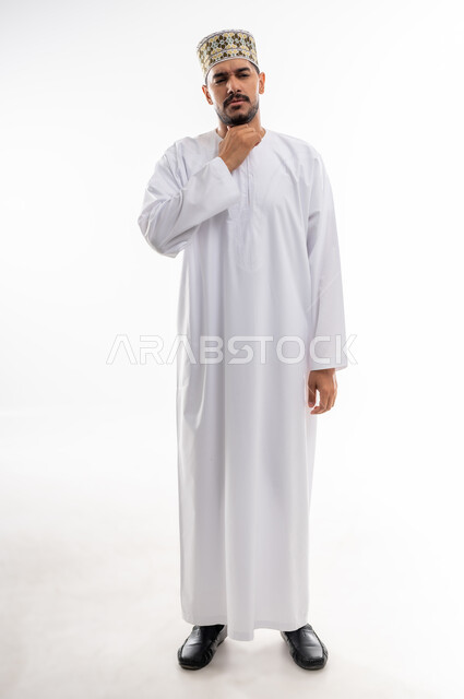 الاحساس بألم البلعوم والحاجة إلى العلاج والدواء, مفهوم الاهتمام بالصحة, الاصابة بنزلة برد والتهاب الحلق, بورتريه لرجل عربي خليجي عماني يرتدي الدشداشه والكمه يضع يده على حلقه بايماءات الشعور بالم الحلق والاحتقان, خلفية بيضاء