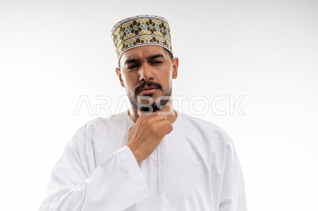 الاحساس بألم البلعوم والحاجة إلى العلاج والدواء, مفهوم الاهتمام بالصحة, الاصابة بنزلة برد والتهاب الحلق, بورتريه لرجل عربي خليجي عماني يرتدي الدشداشه والكمه يضع يده على حلقه بايماءات الشعور بالم الحلق والاحتقان, خلفية بيضاء