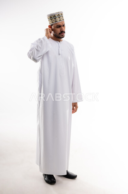 إلتهاب الاذن الحاد وضعف السمع، طلب العلاج والمساعده، بورتريه لرجل عربي خليجي عماني يرتدي الدشداشه والكمه يضع يده على أذنه بإيماءات تدل على الشعور بألم حاد في أذنه و الحاجه لزيارة الطبيب، خلفية بيضاء