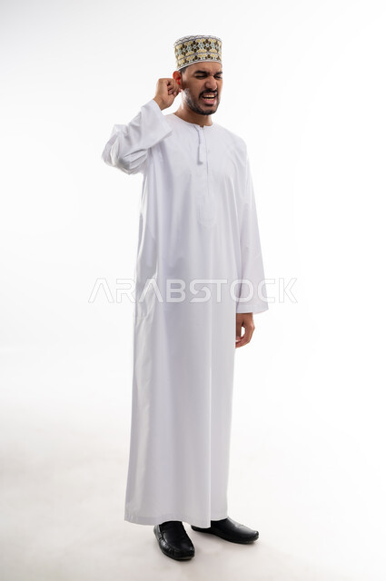 إلتهاب الاذن الحاد وضعف السمع، طلب العلاج والمساعده، بورتريه لرجل عربي خليجي عماني يرتدي الدشداشه والكمه يضع يده على أذنه بإيماءات تدل على الشعور بألم حاد في أذنه و الحاجه لزيارة الطبيب، خلفية بيضاء