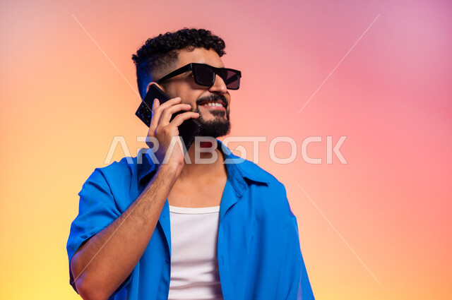 مفهوم اللياقة والرشاقة، المحافظة على التوازن الجسدي، امتلاك جسم رياضي صحي، الاهتمام بالمظهر الخارجي والأناقة، بورتريه لشاب عربي خليجي سعودي يرتدي الزي الكاجوال والنظارات الشمسية, ايماءات الثقة بالنفس، الطول الكامل للجسم، خلفية ملونة