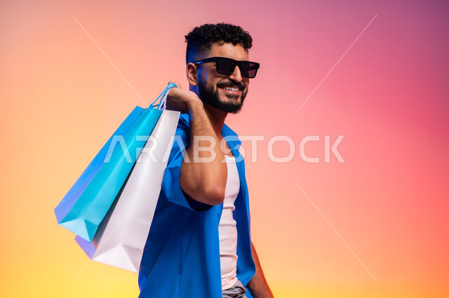 مفهوم اللياقة والرشاقة، المحافظة على التوازن الجسدي، امتلاك جسم رياضي صحي، الاهتمام بالمظهر الخارجي والأناقة، بورتريه لشاب عربي خليجي سعودي يرتدي الزي الكاجوال والنظارات الشمسية, ايماءات الثقة بالنفس، الطول الكامل للجسم، خلفية ملونة