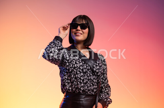 ايماءات الثقة بالنفس، ملامح الانوثة والنعومة, ألبسة خليجية نسائية عصرية، بورتريه مقرب لامرأة عربية خليجية سعودية ترتدي قميص منقط باللون الابيض والاسود، مفهوم الموضة والأناقة، عرض الأزياء والموديلات الحديثة، شراء الملابس والاكسسوارات الجديدة، خلفية ملونة