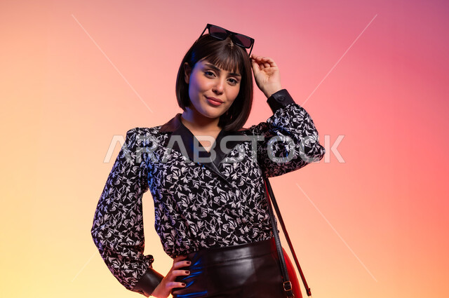 Self-confidence gestures, feminine and soft features, modern Gulf women's clothing, close-up portrait of a Saudi Gulf Arab woman wearing a black and white polka-dot shirt, the concept of fashion and elegance, fashion show and modern models, buying new clothes and accessories, colorful background