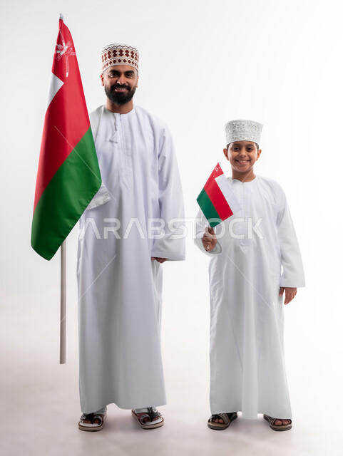 Celebrating Oman National Day, national flags and banners of Arab countries, pride in Omani symbols and banner, portrait of an Arab Gulf Omani boy and young man wearing a dishdasha and a kuma, the concept of love of the homeland and belonging to it, full body, white background