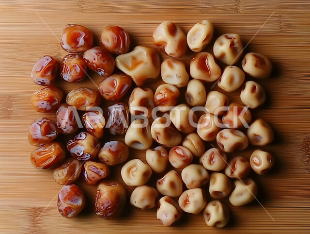 ضيافة رمضانية شهية، الأنواع المختلفة من التمور اللذيذة، وجبة غذائية صحية ذات قيمة عاليه، مجموعة من حبات التمر المجدول المتجعد على لوح خشبي، منتجات وطنية محلية في المملكة العربية السعودية