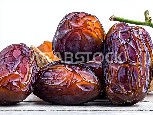 وجبات غذائية صحية ذات قيمة عاليه، مجموعة من حبات التمر المجدول المتجعد، ضيافة رمضانية شهية، الأنواع المختلفة من التمور اللذيذة، منتجات وطنية محلية في المملكة العربية السعودية، خلفية بيضاء