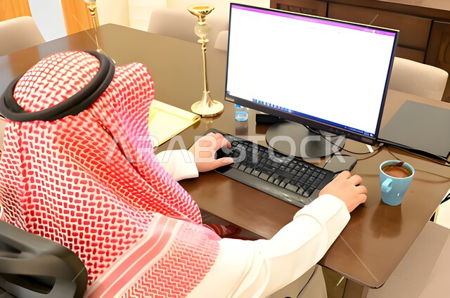 عقد إجتماع عمل عبر الإنترنت، التسويق الإلكتروني، تصفح الإنترنت ، صورة مقربة من الخلف لرجل عربي خليجي سعودي يستخدم جهاز الحاسوب المحمول لإنجاز المهام ، جلسة عمل ، إنجاز المشاريع والمهام، مهن وأعمال تجارية، متابعة ومناقشة العمل