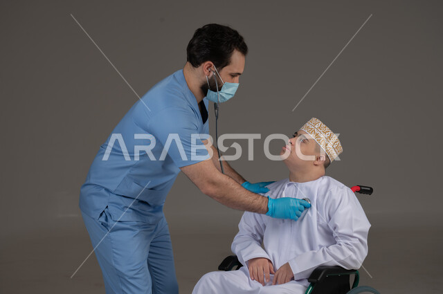 طبيب يشرف على علاج شخص من ذوي الإحتياجات الخاصة والهمم, مفهوم تقديم المساعدة والدعم والعلاج, بورتريه لشاب عربي خليجي عماني يرتدي الكمه والدشداشة يجلس على كرسي متحرك, خلفية رمادي