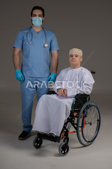 طبيب يشرف على علاج شخص من ذوي الإحتياجات الخاصة والهمم, مفهوم تقديم المساعدة والدعم والعلاج, بورتريه لشاب عربي خليجي عماني يرتدي الكمه والدشداشة يجلس على كرسي متحرك, خلفية رمادي