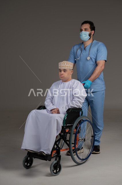 طبيب يشرف على علاج شخص من ذوي الإحتياجات الخاصة والهمم, مفهوم تقديم المساعدة والدعم والعلاج, بورتريه لشاب عربي خليجي عماني يرتدي الكمه والدشداشة يجلس على كرسي متحرك, خلفية رمادي