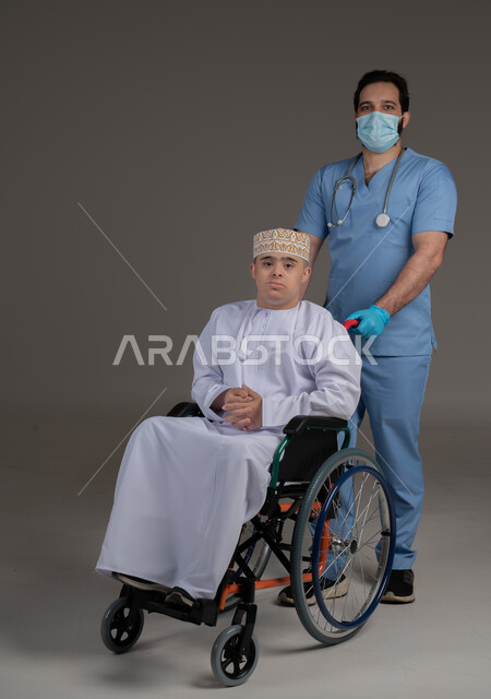 طبيب يشرف على علاج شخص من ذوي الإحتياجات الخاصة والهمم, مفهوم تقديم المساعدة والدعم والعلاج, بورتريه لشاب عربي خليجي عماني يرتدي الكمه والدشداشة يجلس على كرسي متحرك, خلفية رمادي