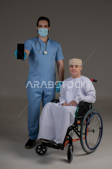 طبيب يشرف على علاج شخص من ذوي الإحتياجات الخاصة والهمم, مفهوم تقديم المساعدة والدعم والعلاج, بورتريه لشاب عربي خليجي عماني يرتدي الكمه والدشداشة يجلس على كرسي متحرك, خلفية رمادي